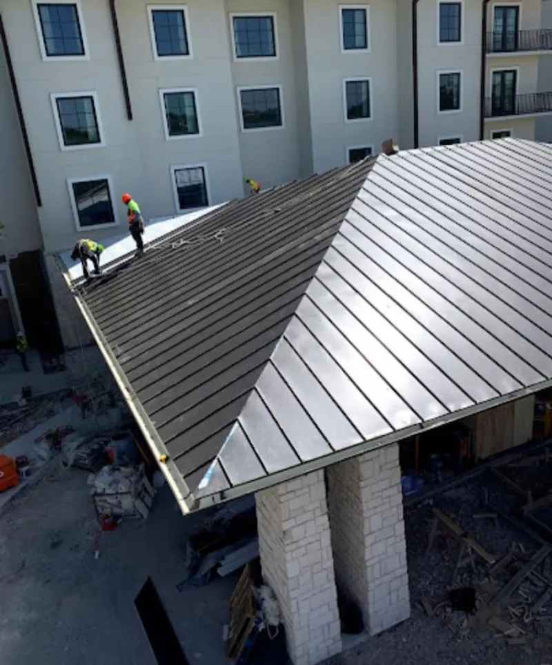 Crew installing standing seam metal roof panels on a commercial project in Ellensburg